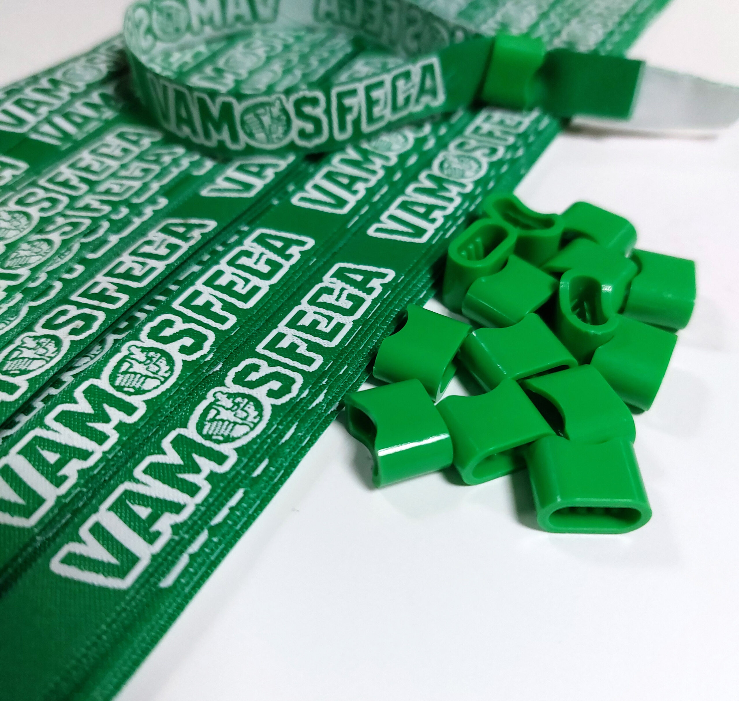 Pulsera Tejida en color verde con diseño personalizado en color blanco. Y broches de plástico verdes.